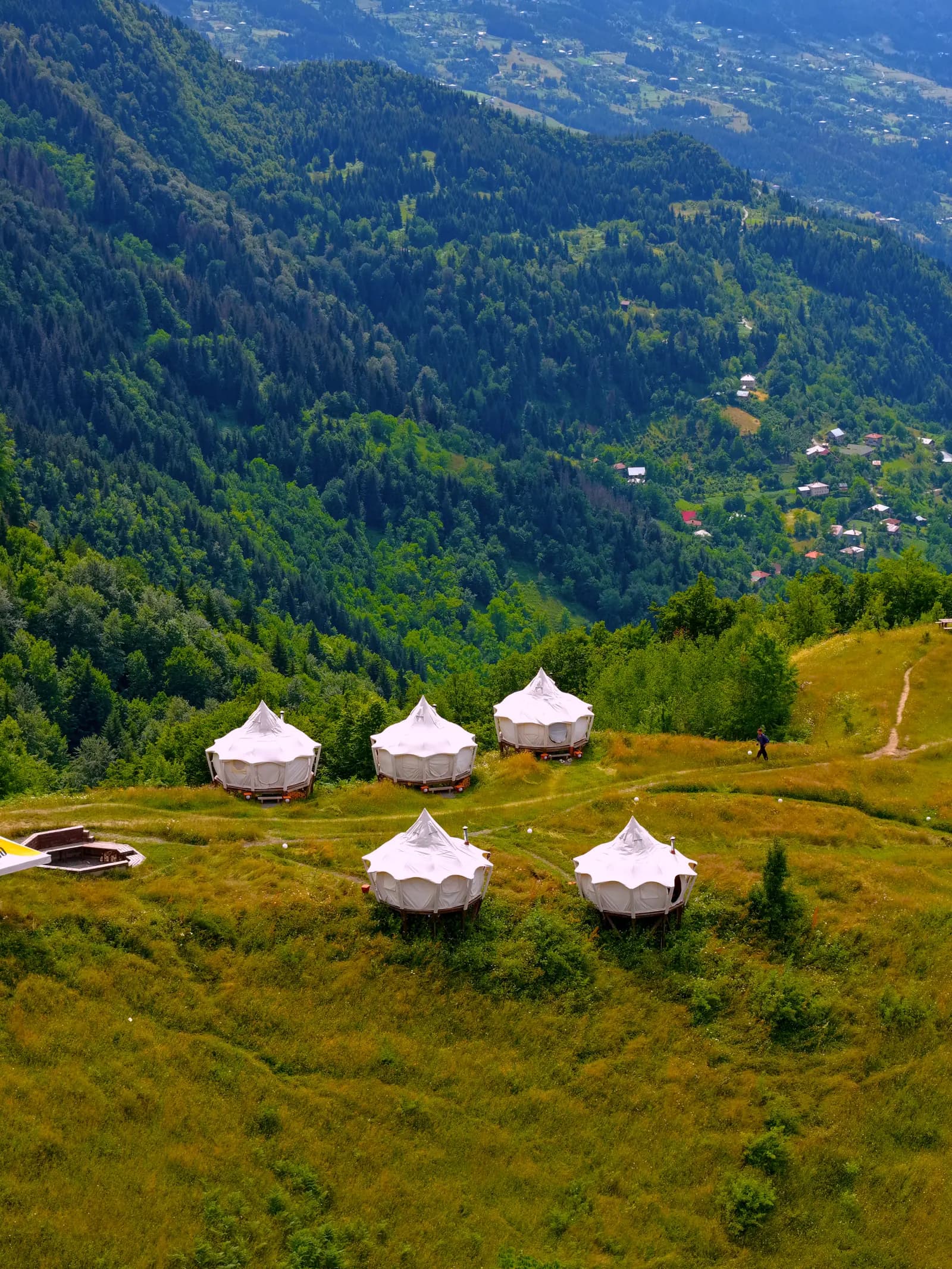 Lotus Belle tents on the green hillside above the valley
