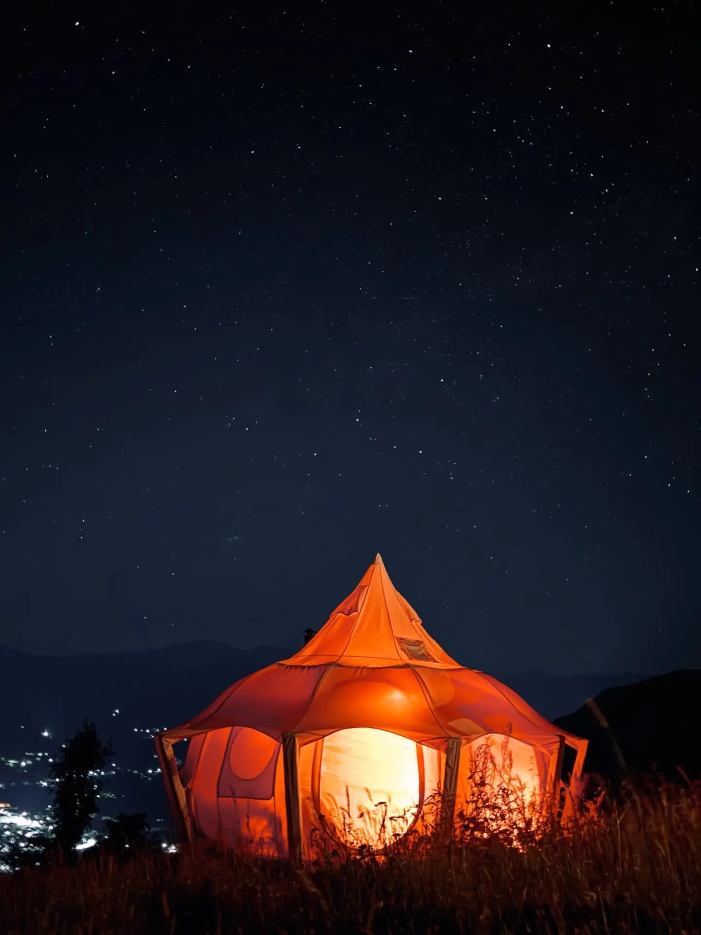 Tent glowing under a starry sky